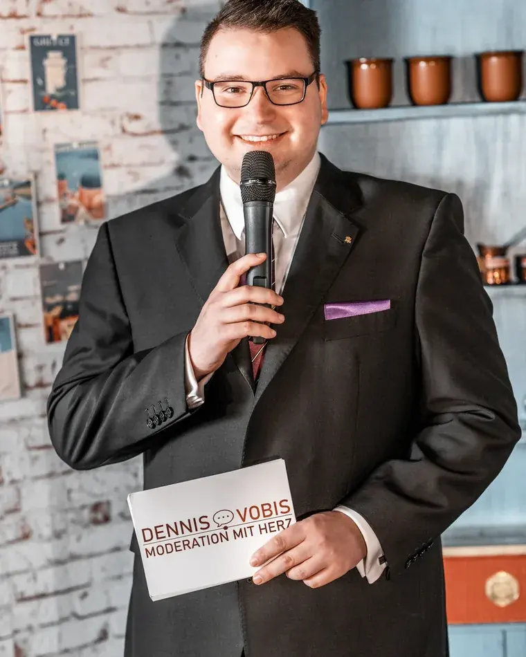 Dennis Vobis moderiert mit Mikrofon